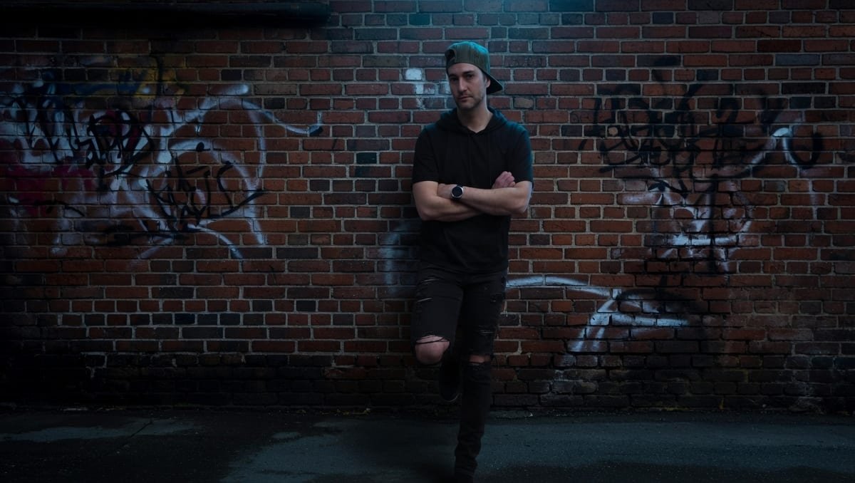 David Birnie at night against a graffiti-covered brick wall
